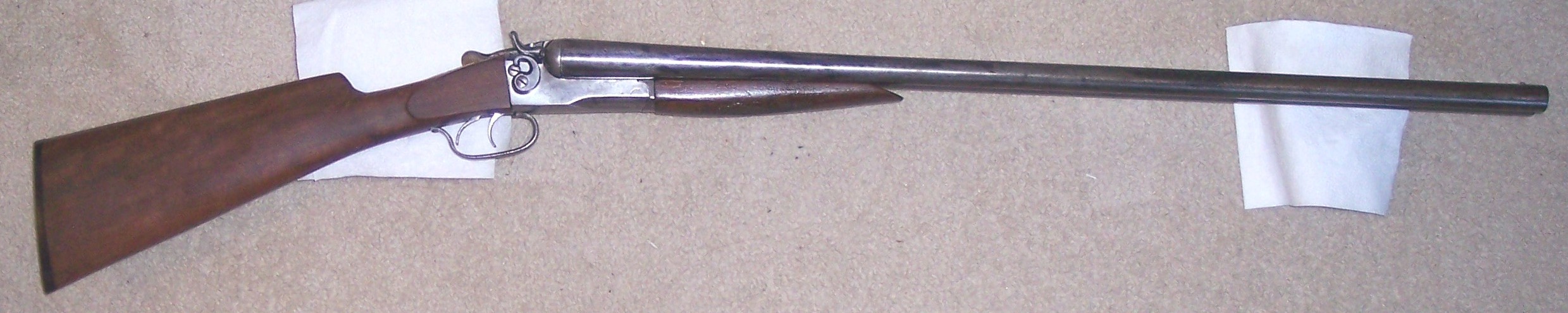 Restored Springfield double-barreled shotgun with new walnut stock made by L. Dietle, originally given by his grandfather Allen Korns to his father Roy Dietle with a broken stock and a farm-repaired hammer. Marked with February 10, 1914 patent date.