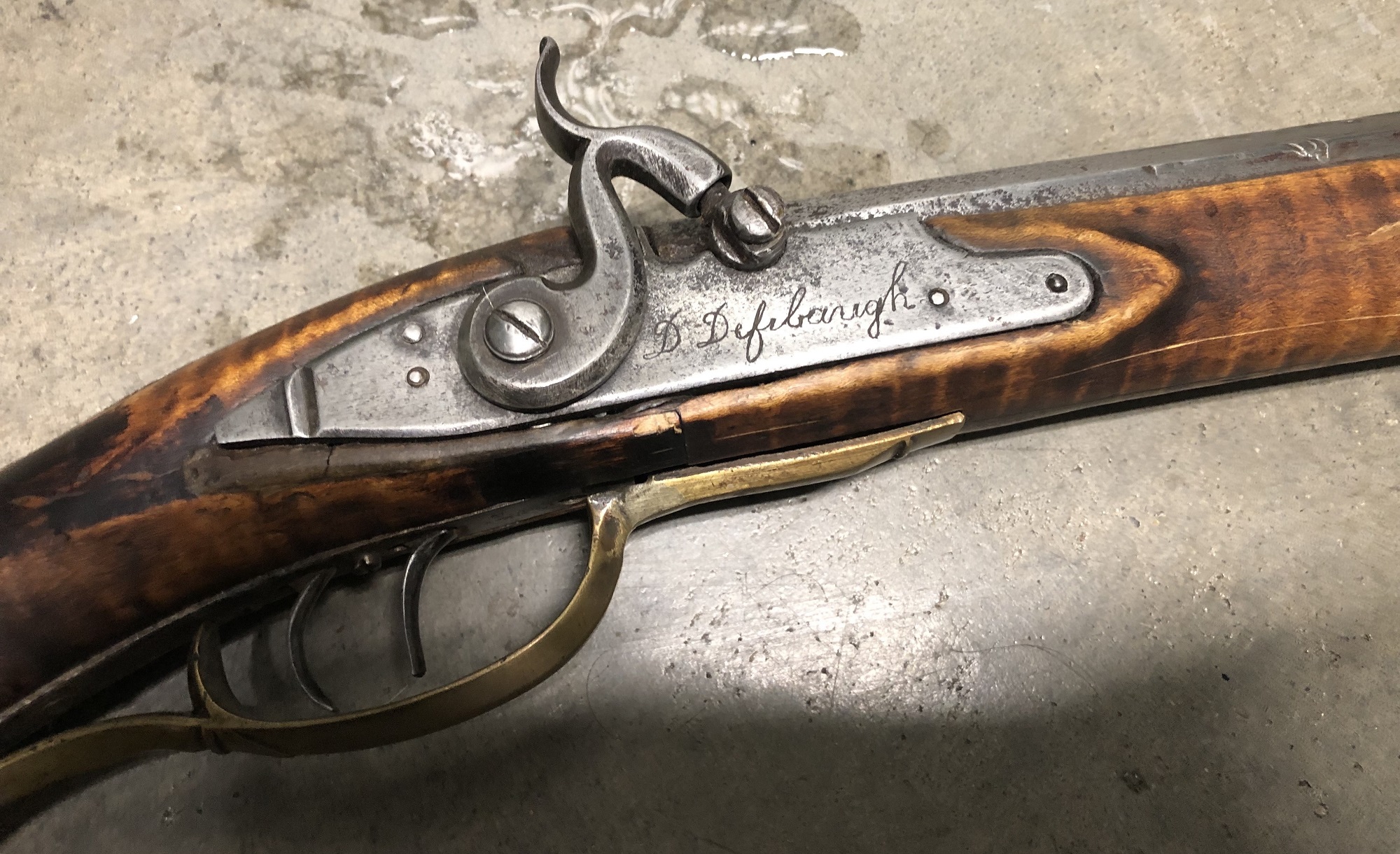 The signed percussion lock of the Defibaugh muzzleloading rifle.