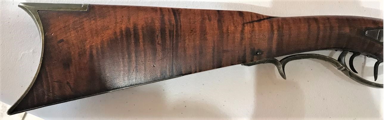 The right-hand side of the buttstock of the Defibaugh muzzle loading black powder rifle.