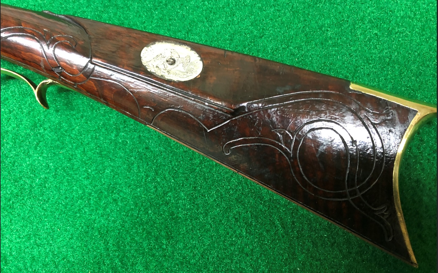 This photograph highlights the left side of the buttstock of an antique black powder muzzle loader rifle created by the gun maker Daniel B. Troutman. He lived in Bedford and Somerset Counties, Pennsylvania before migrating to Kansas.