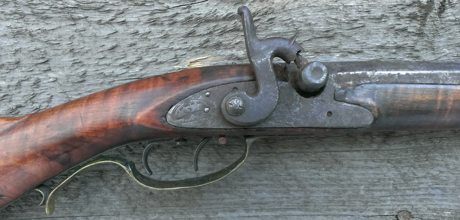 A photo of the percussion lock and the mating panel of the rifle stock.