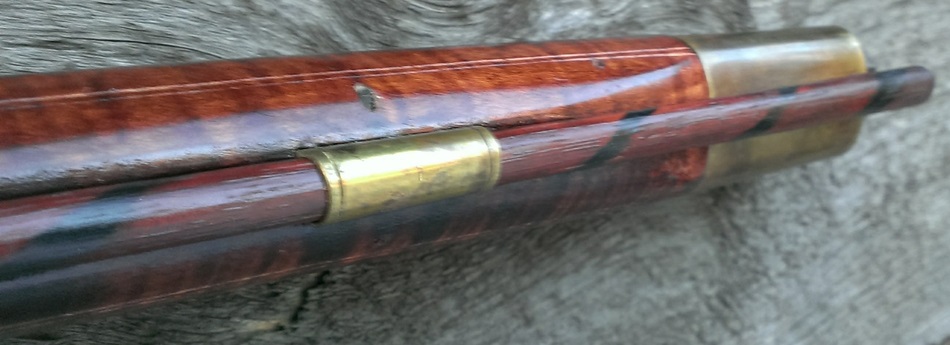 A photo of the forward ramrod pipe, the brass nose cap, decorative incised lines on the fore-end of the stock, and the fore-end transition from grooved to ungrooved.
