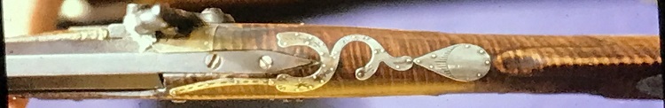 This photograph of the Jacob Stoudenour rifle shows the barrel tang, the brass stock protector in the hammer area, and the inlays on the top of the stock forward of the comb, in wrist area and near the breech.