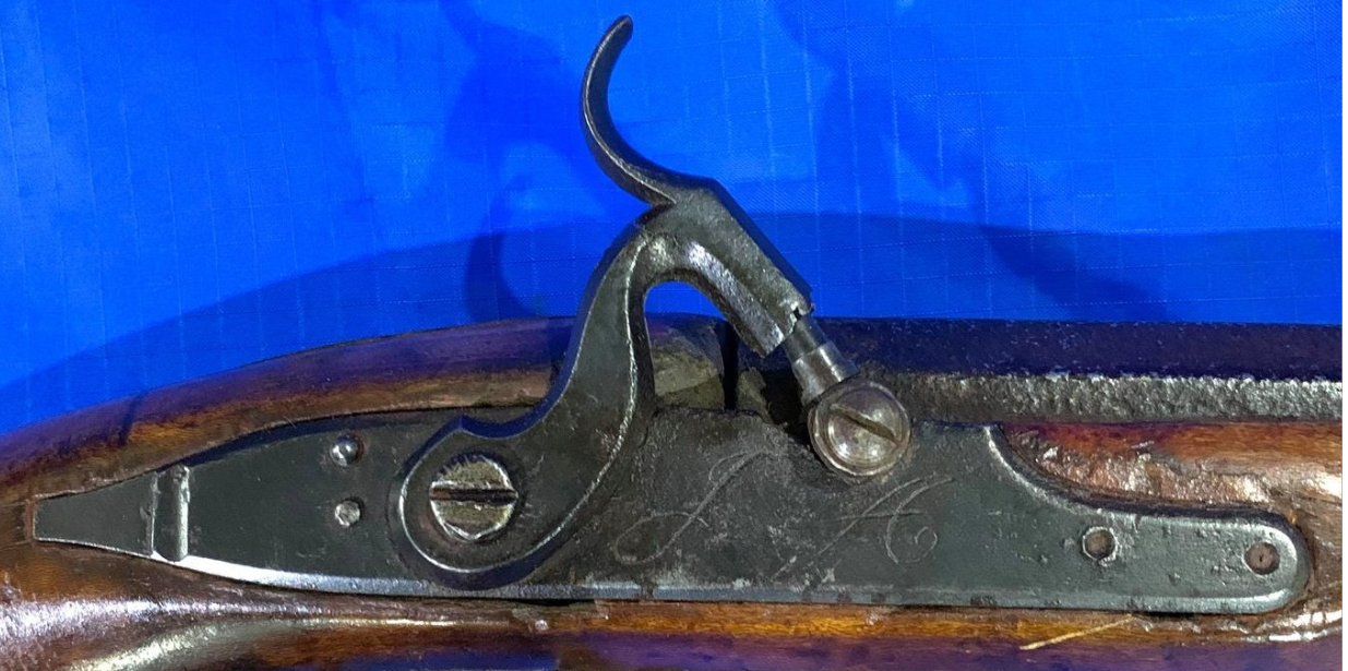 A closeup enlarged view of the lock of a Pennsylvania long rifle that was made by John Amos of Bedford County, PA.