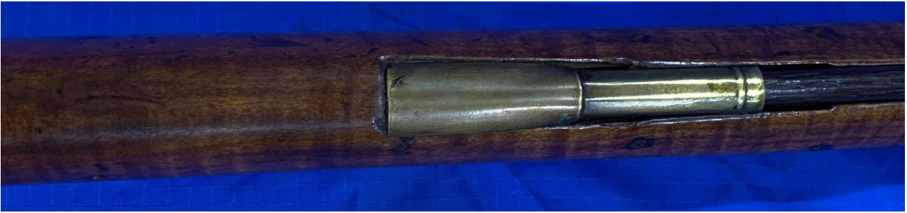 A bottom view of the entry pipe area of a long rifle made by John Amos of Bedford County, Pennsylvania.