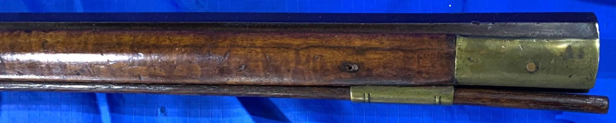 A photo of part of the right-hand side of the forearm of a percussion Pennsylvania long rifle by gun maker John Amos of Bedford County, PA.