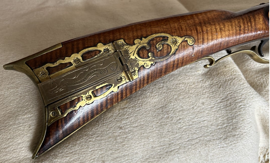 The patchbox side of the buttstock of the Samuel Mier half-stock muzzleloader.
