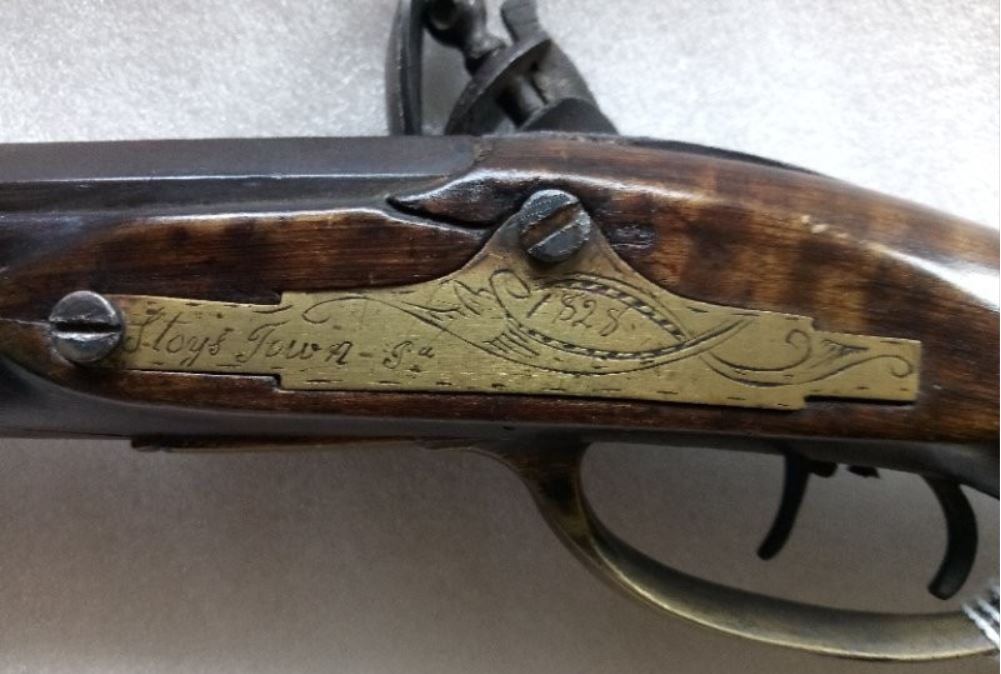 The 1828-dated lock bolt plate on the Spangler flintlock rifle.