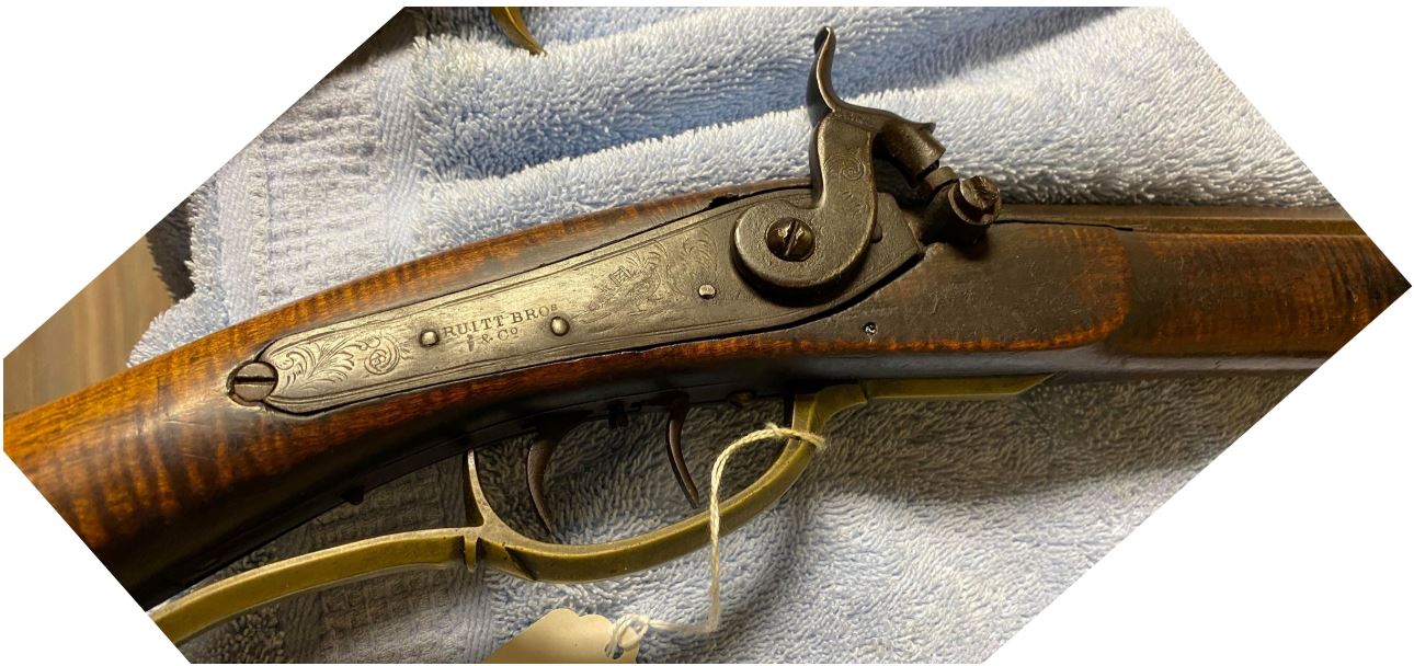 The back action lock that is mounted on an antique muzzle loading black powder rifle that was made by Tobias Snider of Bedford County, Pennsylvania.