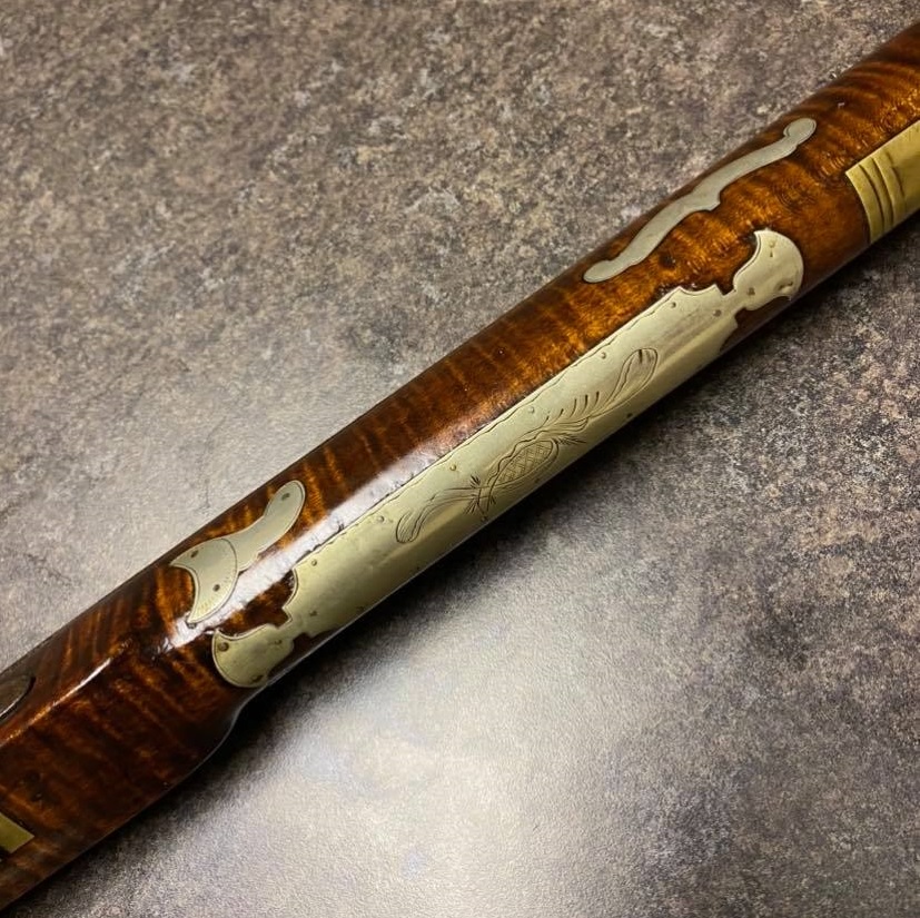 A picture of the forearm wear plate and some inlays on a percussion rifle that was made by the Bedford County gunsmith Tobias Snider.