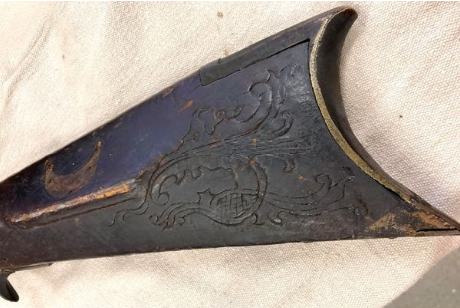 This photograph shows the carving behind the cheekpiece on a rifle that has been attributed to the gun maker Jacob Mier, who lived and worked in Somerset County, Pennsylvania.