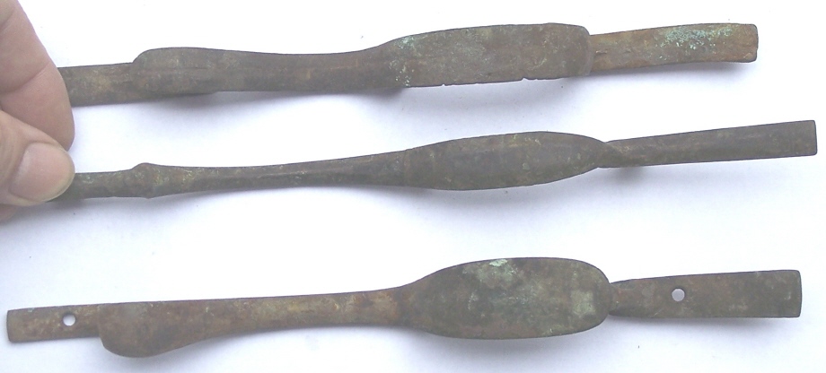A bottom view of three antique trigger guards for muzzle loading rifles that were found on the Lepley farm.