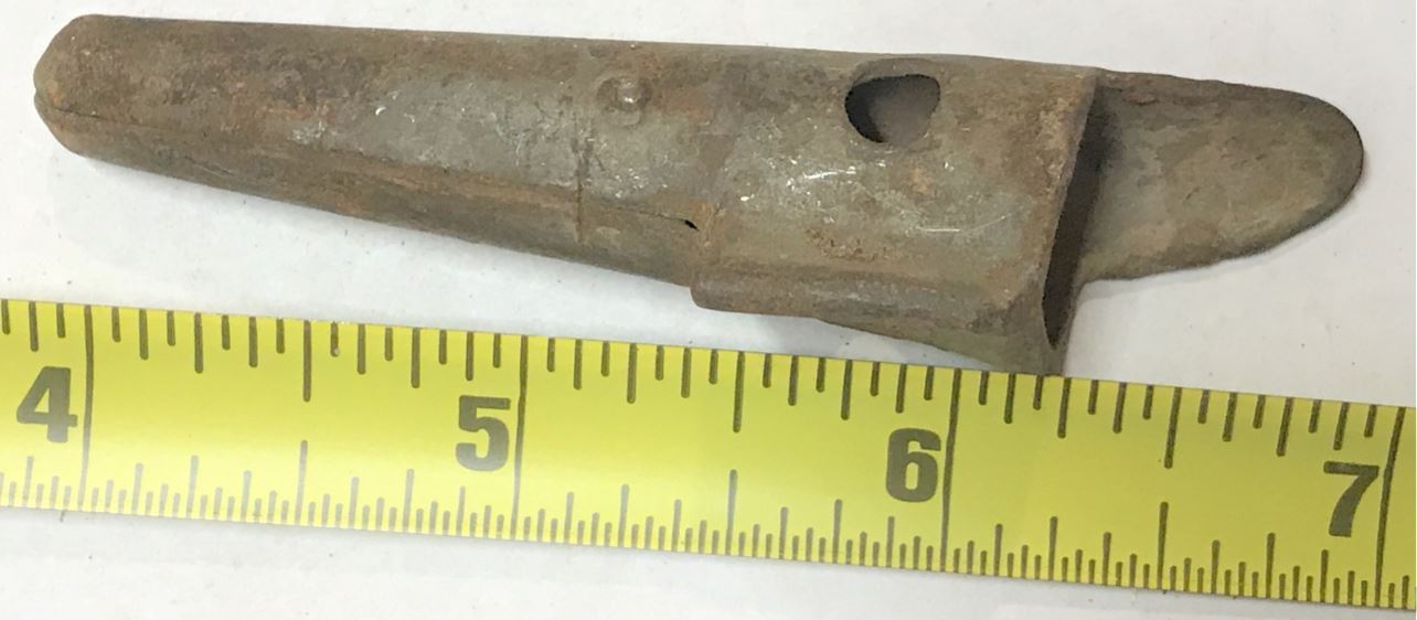 Another view of the old sugar water tap, shown with a ruler to illustrate the size of the item.